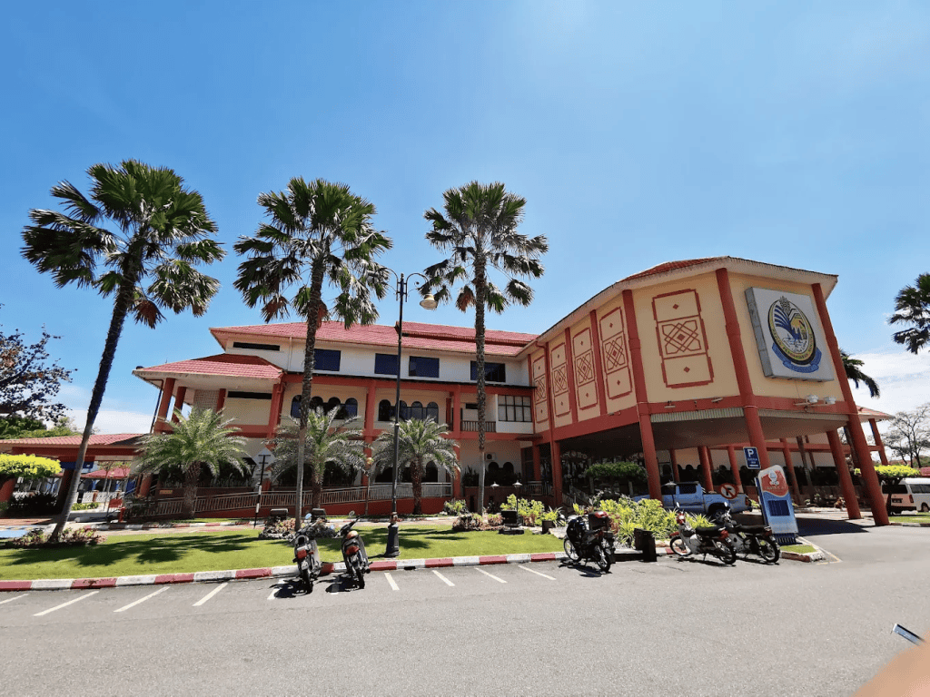Modern university building with palm trees surrounding the campus, featuring the myPATIL Portal logo, ample parking, and clear blue sky, representing a leading educational institution's online portal access.